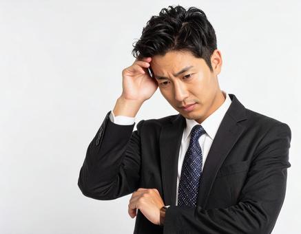 頭を抱えて頭痛に悩む男性 頭を抱えて頭痛に悩む男性の写真