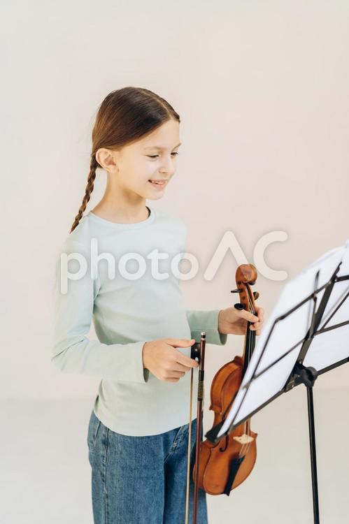 楽譜を見てバイオリンを持っている女の子 女の子,バイオリン,笑顔の写真素材