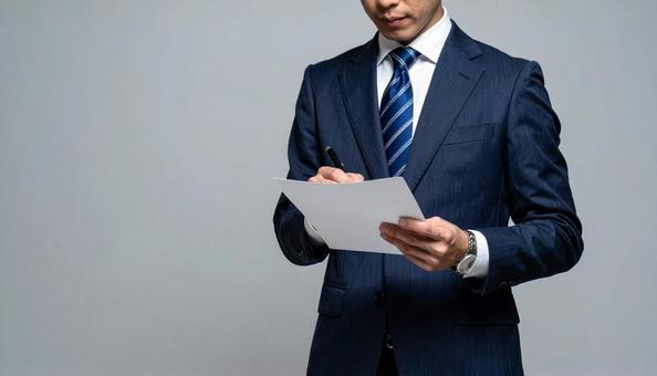 契約イメージ書類にサインするビジネスマンの写真