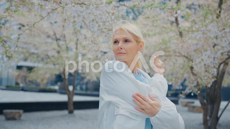遠くを見て肘を伸ばす女性 女性,人物,元気の写真素材