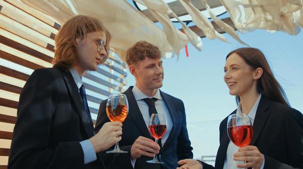 笑顔の女性の話を聞く男性2人 男女,ワイングラス,ワインの写真素材