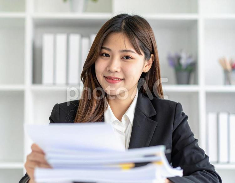 たくさんの書類を処理する女性社員 書類,オフィス,女性の写真素材