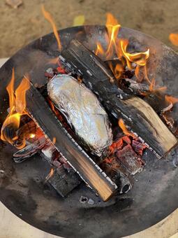 焚き火で焼き芋（縦構図） 焚き火,薪,キャンプの写真素材
