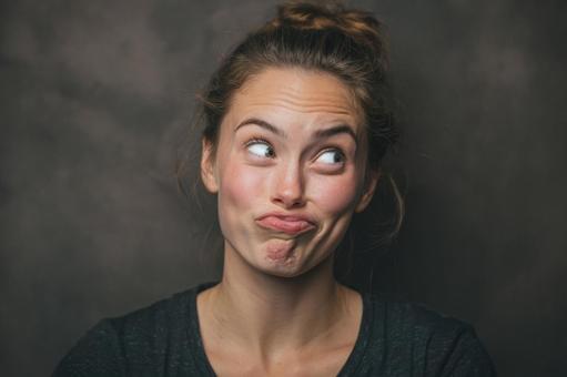 何かを考えているような、面白い顔の女性の写真