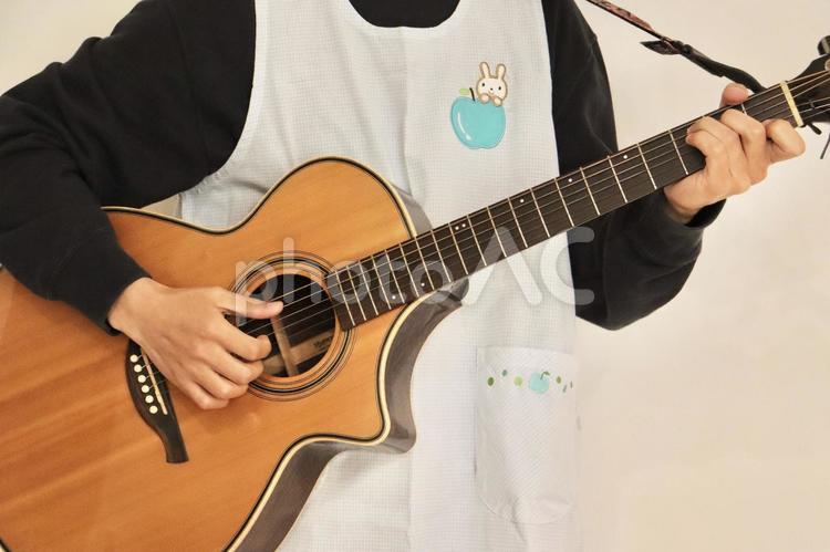 男性　保育士　ギター 男性,保育士,エプロンの写真素材