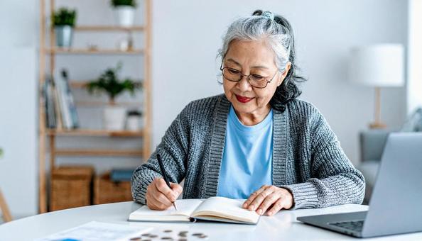 家計簿をつけるシニア女性の写真