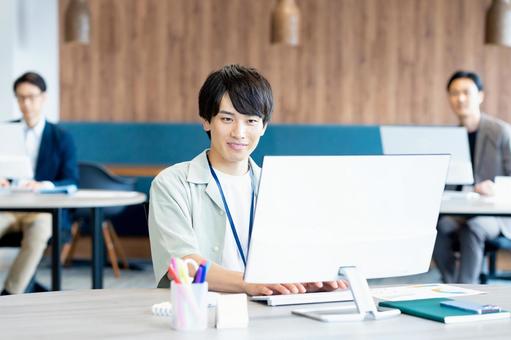 オフィスで働く若いビジネスマン オフィスで働く若いビジネスマン ビジネスマン,笑顔,オフィスの写真素材
