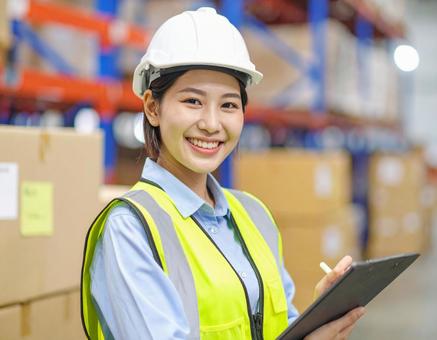 倉庫で在庫をチェックする女性作業員 倉庫で在庫をチェックする女性作業員の写真
