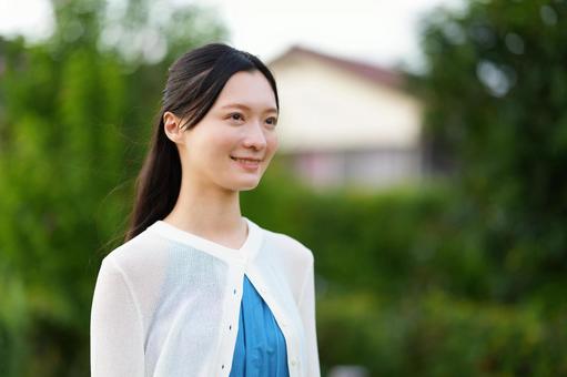 屋外で笑うハーフアップの女性の写真