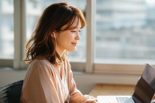 オンライン会議に参加する女性 オンライン会議に参加する女性の写真