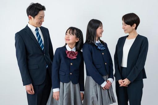 スーツを着た男女と制服を着た女の子二人 入学式,父母,母親の写真素材