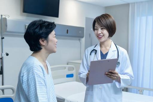 患者とコミュニケーションをとる女性医師 患者とコミュニケーションをとる女性医師の写真
