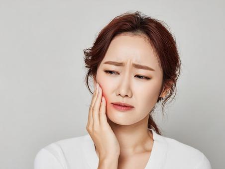 虫歯の痛みに悩む若いアジア人女性 虫歯の痛みに悩む若いアジア人女性の写真