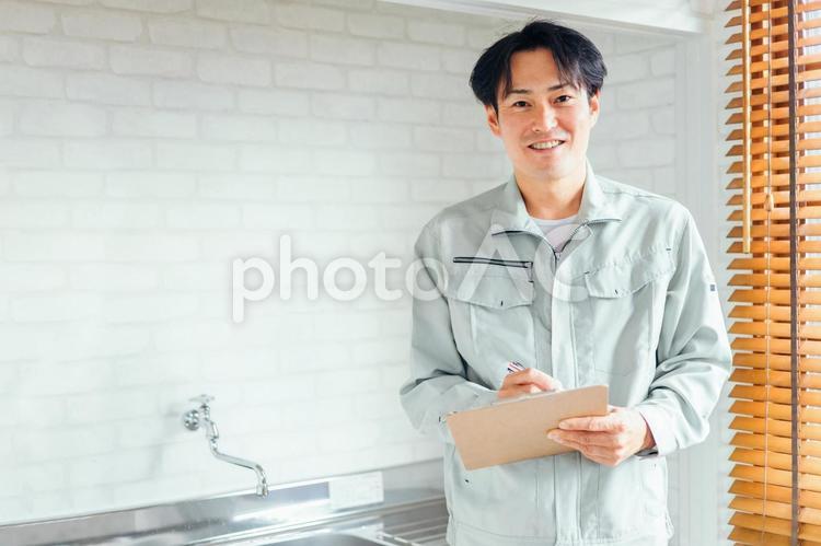 水道をチェックする作業着の男性 水道,蛇口,水の写真素材