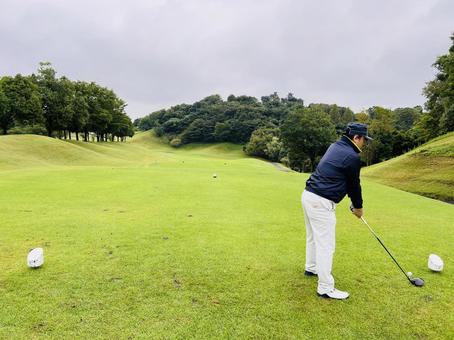 起伏あるコースでティーショットをする男性 ゴルフ,ゴルフ場,男性の写真素材