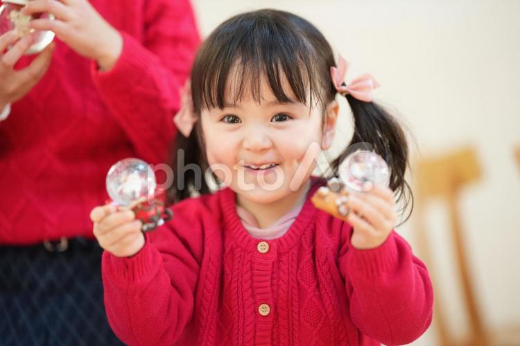 両手にスノードームを持つ女の子 女の子,クリスマス,スノードームの写真素材