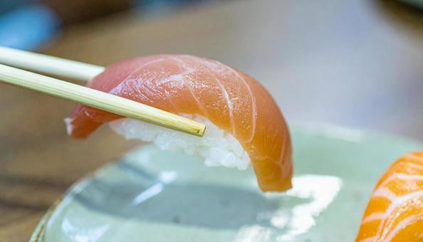 皿に盛られた美味しそうな寿司を箸でつまむ 皿に盛られた美味しそうな寿司を箸でつまむ お寿司,握り,握り寿司の写真素材