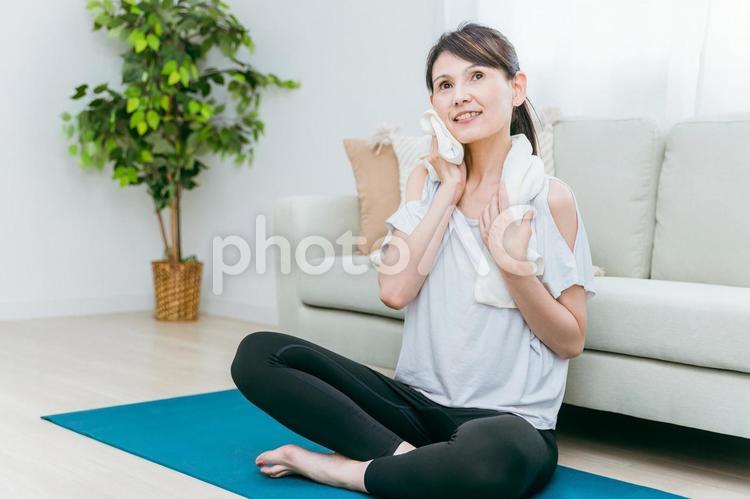 部屋でヨガをする中高年女性（タオル） ホットヨガ,ヨガ,ストレッチの写真素材