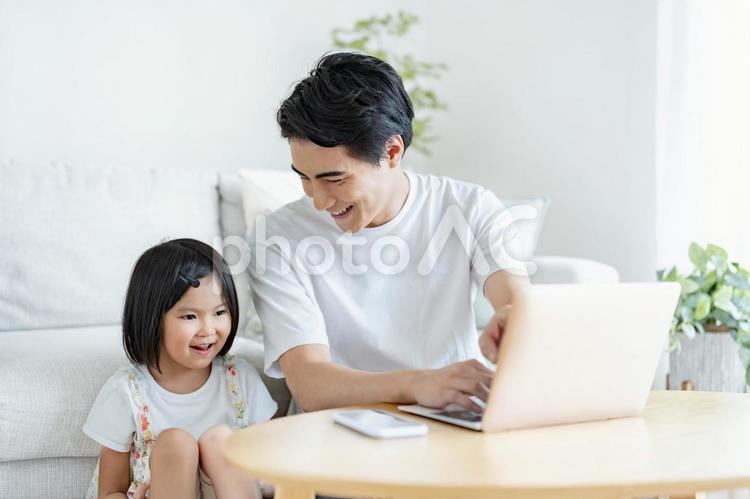 パソコンを触るお父さんと一緒にみる娘 子供,父親,女の子の写真素材