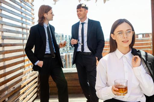 立ち話中の男性の前に立つグラスを持った女性 男女,外国人,微笑むの写真素材