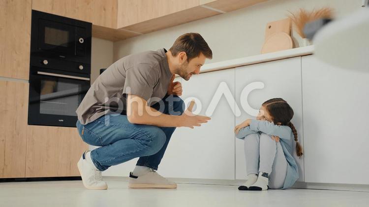 女の子に寄り添って話す男性とチラ見する女の子 親子,男性,女の子の写真素材