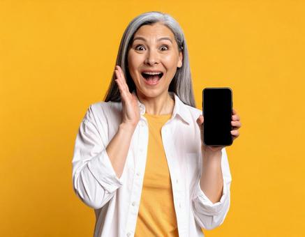 スマホを見て驚く中年女性(黄色背景) スマホを見て驚く中年女性(黄色背景)の写真
