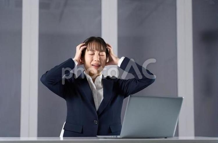 残業で頭を抱えるビジネスウーマン ビジネスウーマン,女性,残業の写真素材