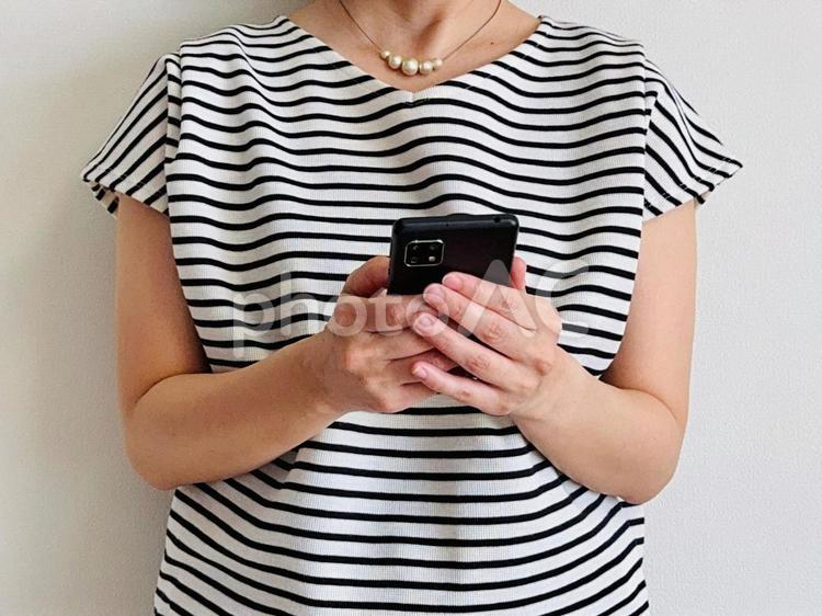 スマホを操作するボーダーの女性 スマホ,女性,snsの写真素材