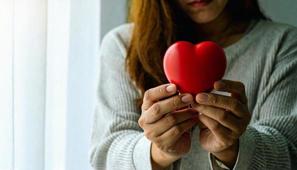 破れたハートを持って悲しそうな顔の女性 破れたハートを持って悲しそうな顔の女性の写真