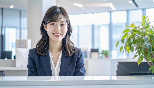 笑顔で対応する女性の受付嬢 笑顔で対応する女性の受付嬢の写真