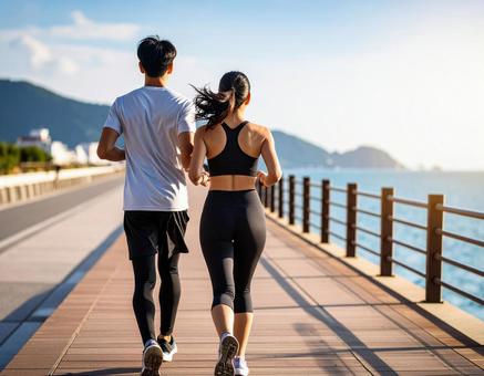 海沿いをペアでランニングする男女 海沿いをペアでランニングする男女の写真