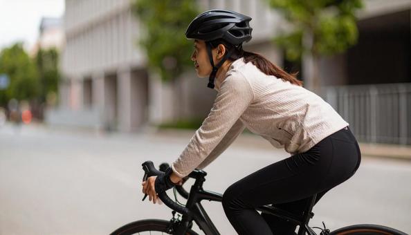 ロードバイクでサイクリングする女性 ロードバイクでサイクリングする女性の写真