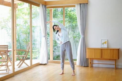 リビングで体操をする女性の写真