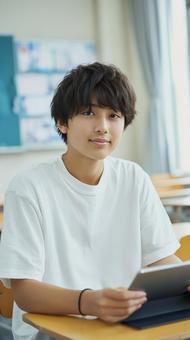 タブレット端末を手にした爽やかな男子学生 タブレット端末を手にした爽やかな男子学生の写真