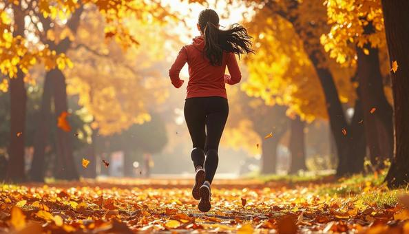 スポーツの秋 紅葉の中を走る女性 後ろ姿 スポーツの秋 紅葉の中を走る女性 後ろ姿の写真