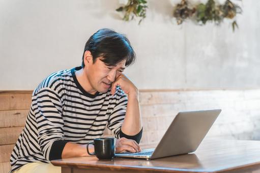 パソコンを見て落ち込むオーナーの男性 パソコンを見て落ち込むオーナーの男性 カフェ,オーナー,男性の写真素材