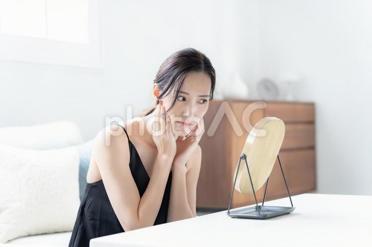 鏡を見て不満げな女性 悩む,自宅,準備の写真素材