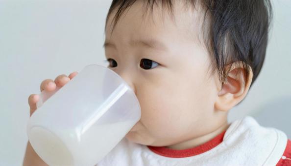 哺乳瓶からミルクを飲む赤ちゃん 哺乳瓶からミルクを飲む赤ちゃんの写真