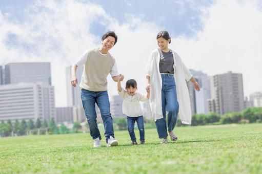手を繋いで屋外を散歩する親子 手を繋いで屋外を散歩する親子 人物,家族,女性の写真素材
