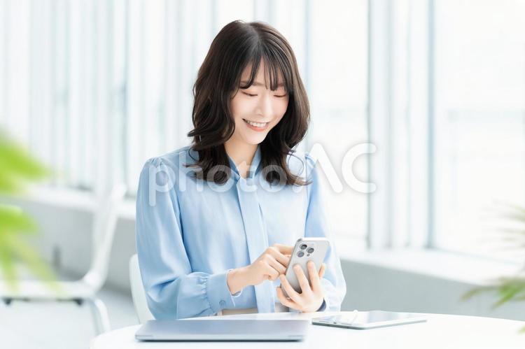 スマホを使う笑顔の女性・ビジネスウーマン 女性,ビジネス,笑顔の写真素材