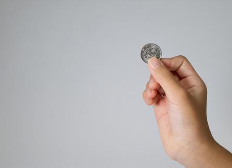 100円硬貨を持つ手と余白 100円玉,硬貨,お金の写真素材