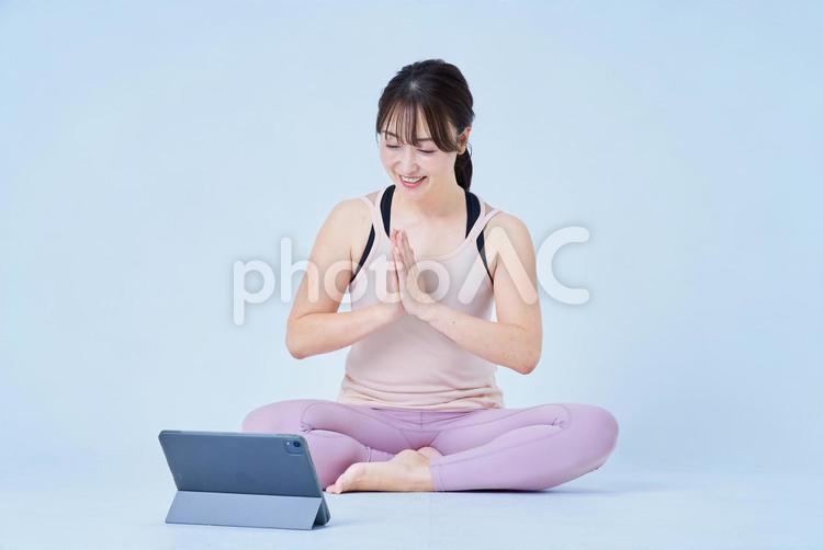 スポーツウェア姿でPCの画面を見る女性 ヨガ,フィットネス,レッスンの写真素材