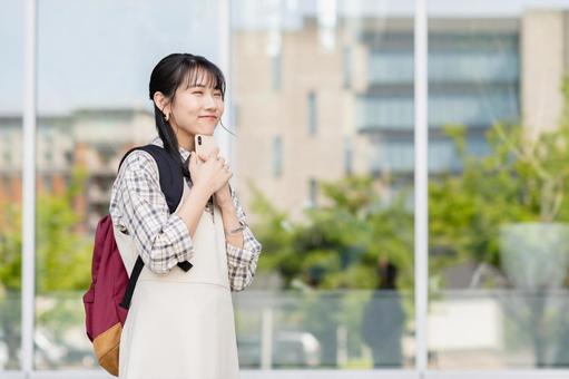 キャンパスでスマホを使う女子大学生 キャンパスでスマホを使う女子大学生 キャンパス,大学,大学生の写真素材