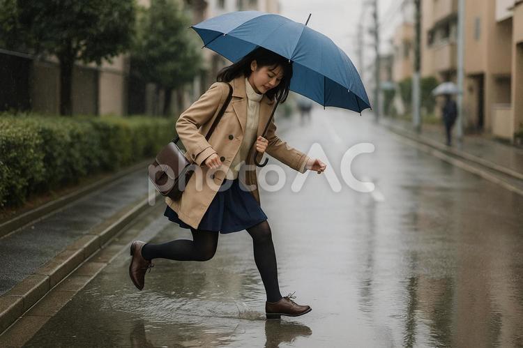 雨の日に水たまりを跳ぶ 女性,雨,水たまりの写真素材