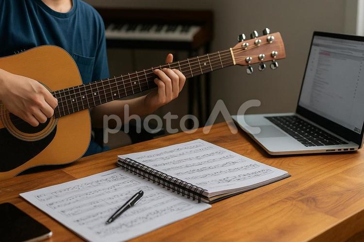 木製デスクに置かれたギターと譜面 ギター,楽譜,音楽の写真素材