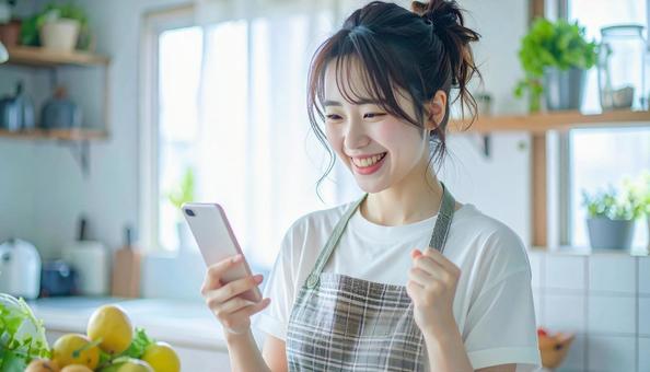 スマホでポイ活する笑顔の女性 スマホでポイ活する笑顔の女性の写真