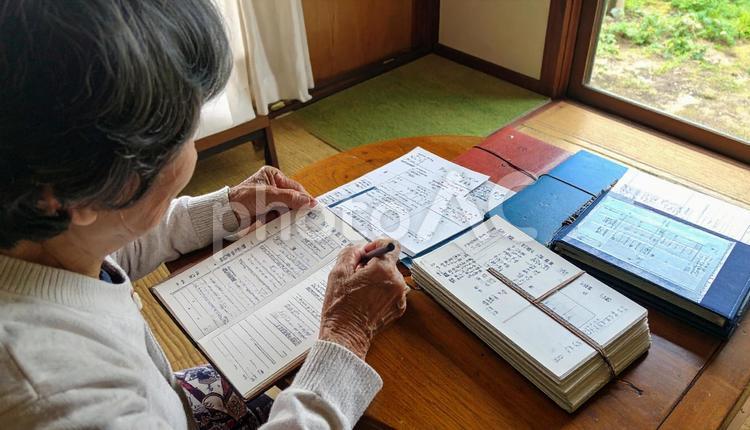 家計簿をつけるシニア女性の手もと 家計,家計簿,会計の写真素材