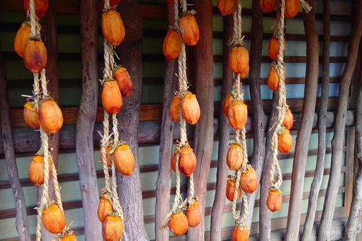 軒下につるされた干し柿の写真