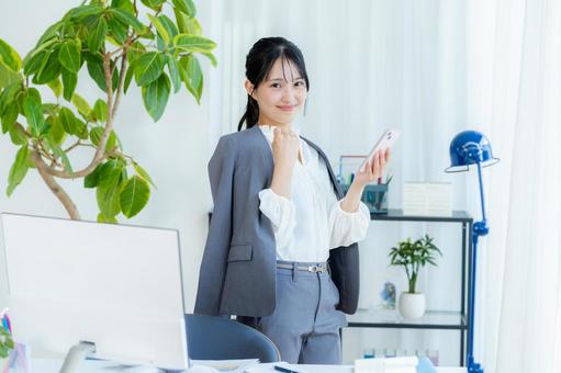 スマホを操作するビジネスウーマン ビジネスウーマン,スマホ,笑顔の写真素材