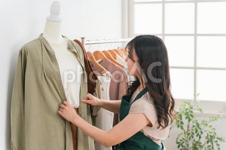 洋服屋でディスプレイを作るショップ店員 マネキン,トルソー,ディスプレイの写真素材